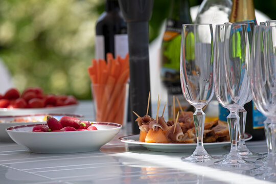 Table d'ap&eacute;ritif en &eacute;t&eacute; dans le jardin avec amuse-bouche, zakouskis et tapas et fl&ucirc;tes &agrave; champagne.