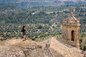 Girl photographing the bell tower of La Fresnada village