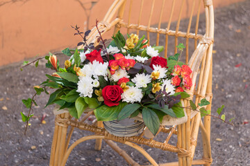 Fototapeta na wymiar Still Life with beautiful bouquet on cane-chair. selective focus