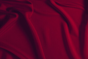 Red silk or satin luxury fabric texture can use as abstract background. Top view.