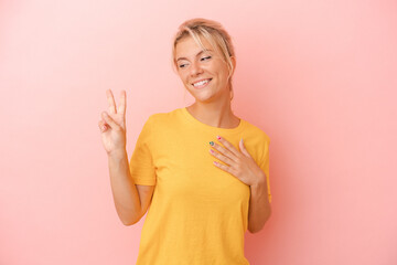 Young Russian woman isolated on pink background taking an oath, putting hand on chest.