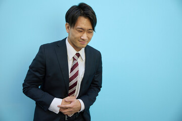 お腹を押さえる日本人男性　サラリーマン