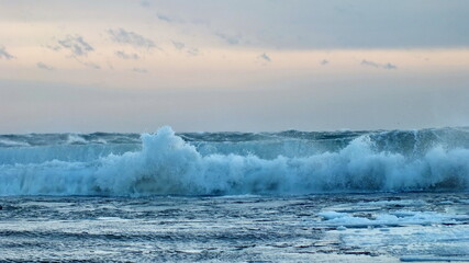 Waves with floating ice break against the shoreline in Toronto, Ontario, Canada, during a winter storm.