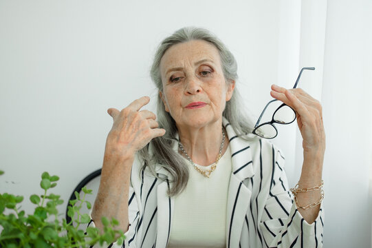 Tired Senior Grey Haired Businesswoman In Striped Jacket With Eyeglasses Is Working In Her Office Sitting At The Desk And Feeling Bad Due To Menopause, Menopause Relief Concept