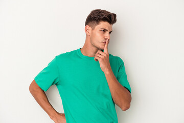 Young caucasian man isolated on white background keeping a secret or asking for silence.