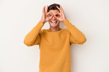 Young caucasian man isolated on white background excited keeping ok gesture on eye.