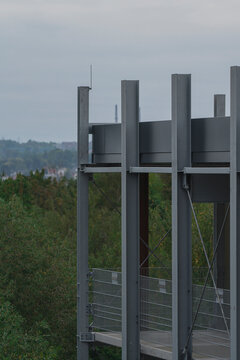 a part of the outer side of a high rise parking garage in a industry area with trees in the background 