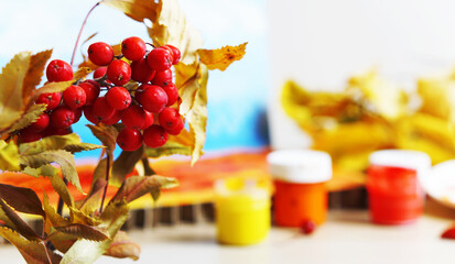 Red rowan with yellow leaves in the foreground, the background is blurred. Place for your text. Advertising image concept