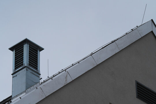a metallic roof with a metallic chimney with a blue sky in the background