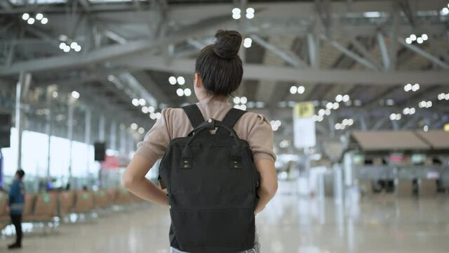 lockdown is over time to travel,happiness attractive traveller asian femlae casual cloth hand wave gesture smiling walking along in terminal airport cheerful smile happiness safety travel concept