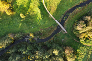 Beautiful colors of autumn. Forest, meadow and river with bridge photographed with a drone on sunny day. Regional park of neris in Lithuania. Dukstai educational trail. Real is beautiful  