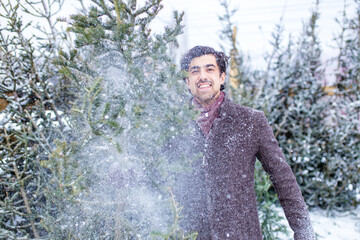 Fototapeta na wymiar italian man buying Christmas tree at X-mas new year in open air shop