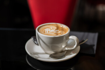 Cappuccino coffee in a white cup in an italian cafe