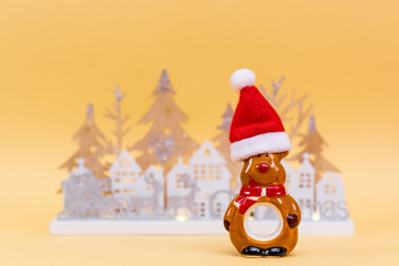 Merry Christmas and Happy Holidays. Christmas reindeer in santa hat on yellow background