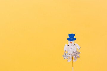 Christmas composition. Christmas snowman on light yellow background, copy space.Beautiful new year