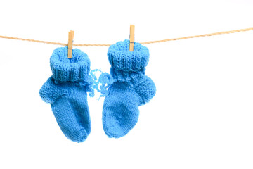 Baby clothes on a clothesline on white  background . knitted socks