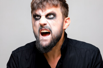 Portrait of a man with a beard and a menacing look with undead-style makeup on All Saints' Day on October 31