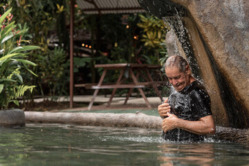 elderly latin man enjoying a natural hot spring pool 