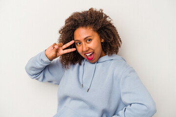 Young african american woman with curly hair isolated on white background dancing and having fun.