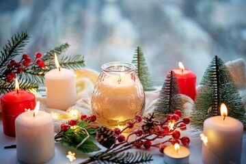 Winter Christmas holidays background with candles; christmas light; Cup of cocoa with marshmallow or hot chocolate near a window
