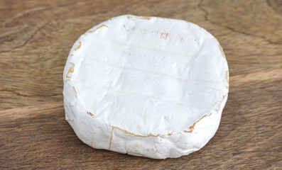 Camembert on a wooden board. Camembert cheese on a board close-up.