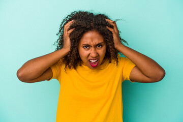 Fototapeta na wymiar Young african american woman with curly hair isolated on blue background screaming, very excited, passionate, satisfied with something.