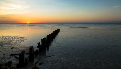 Beautiful sunset in the blue hour, in which the tide goes down and you can see the sand with small waves.