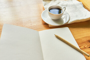 Flat lay with notebook, pen and coffee on a wooden table. Work at home concept. Comfortable workplace. Morning ritual before work