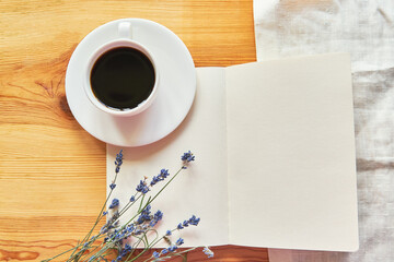 Flat lay with a notebook, lavender, and coffee on a wooden table. Work at home concept. Comfortable workplace. Morning ritual before work