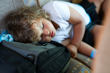 child sleeping on a suitcase