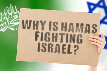 The question " Why is Hamas fighting Israel? " on a banner in men's hand with blurred Israeli and Hamas flag on the background. Conflict. War. Destruction. Violence. Missle. Confrontation. Military