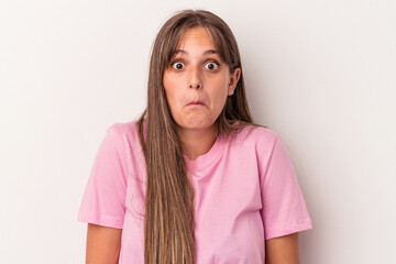 Young caucasian woman isolated on white background shrugs shoulders and open eyes confused.