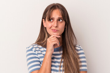 Young caucasian woman isolated on white background looking sideways with doubtful and skeptical expression.