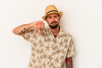 Young caucasian man with tattoos wearing summer clothes isolated on white background  showing a dislike gesture, thumbs down. Disagreement concept.