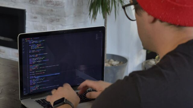 Young guy developer working with computer at home office