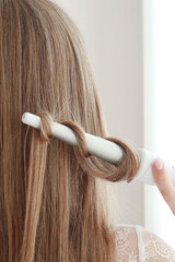 Fototapeta premium Female hair and curler, close up