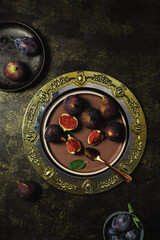 Sweet figs in a bowl on a textured table with a velvet napkin. Autumn composition from the top perspective 