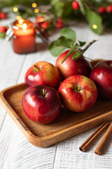 Autumn background with apples, cinnamon, hawthorn and christmas lights