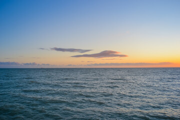 Sea at sunset, clear sky and light waves