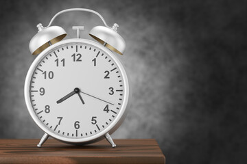 A vintage silver alarm clock stands on the edge of a wooden table against a dark background. 3D render.