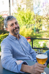 homme de 50 ans se détend au soleil en buvant une bière. Il se repose et il es zen
