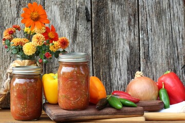glass jars of homemade salsa with fresh vegetables