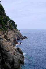 view of breakwater and sea cliff of portofino, liguria, italy with the blue sea