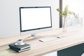 Close up of creative wooden designer desktop with empty white mock up computer monitor, coffee cup, other items, window with city view and daylight. 3D Rendering.