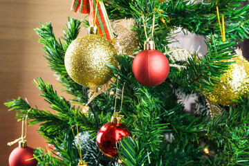 Christmas tree assembled with ornaments. Red, silver and gold balls, gift boxes, lights, Santa Claus and others. Selective focus.