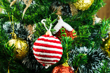 Christmas tree assembled with ornaments. Red, silver and gold balls, gift boxes, lights, Santa Claus and others. Selective focus.