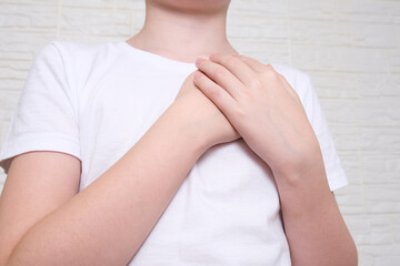 A boy showing gratitude gesture on white background, he is hopeful while praying