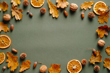 Autumn background with dry oranges, fallen oak leaves, acorns, walnuts. Autumn frame. Happy Thanksgiving day greeting card template