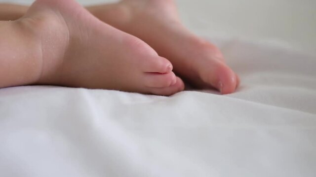Close-up of the foot of a little boy sleeping on a bed