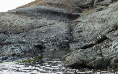 Black Sea coast. A seashore formed by frozen volcanic lava. Tectonic rocks.